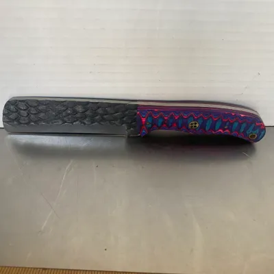 Sale Photo Thumbnail #30: Custom straight razor with a textured, scale-patterned spine and a vibrant purple, pink, and blue layered G10 handle.