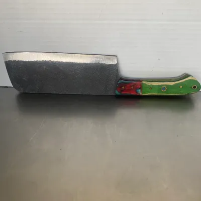 Sale Photo Thumbnail #40: Handcrafted cleaver knife fashioned from a metal file, featuring a colorful laminated wood handle in green and red tones with mosaic pins.