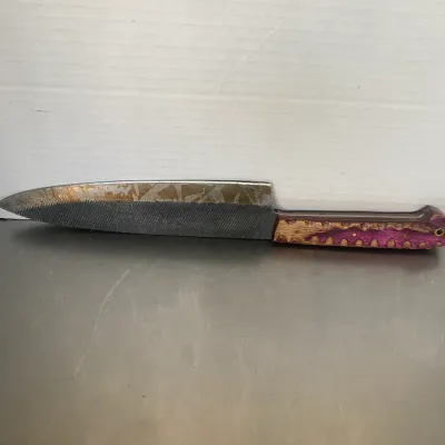 Sale Photo Thumbnail #48: Handcrafted knife fashioned from a metal file, featuring a textured blade and a custom purple and natural wood handle.