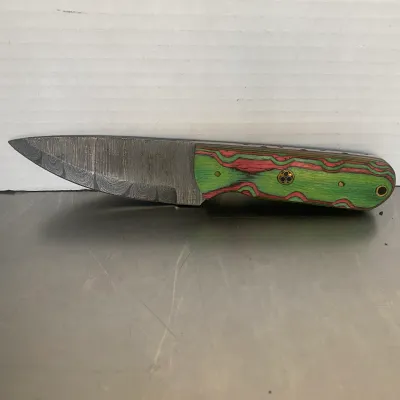 Sale Photo Thumbnail #68: Custom fixed-blade knife featuring a Damascus steel blade and a vibrant green and pink laminated wood handle with brass mosaic pins.