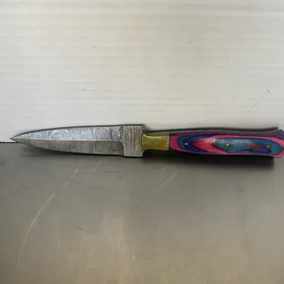 Sale Photo Thumbnail #47: Damascus steel dagger featuring a colorful laminated wood handle in shades of pink, blue, and purple with brass bolster and pins.