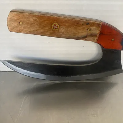 Sale Photo Thumbnail #33: Handcrafted ulu knife featuring a curved steel blade and a wooden handle with decorative mosaic pins.