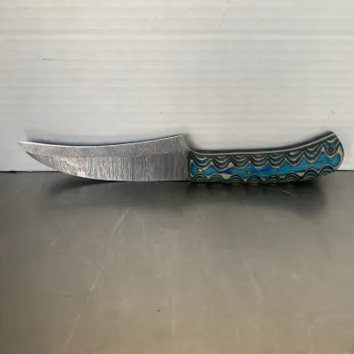 Sale Photo Thumbnail #36: Custom fixed-blade knife featuring a Damascus steel blade and a textured blue and grey composite handle.