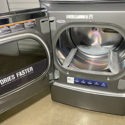Sale Photo Thumbnail #18: Modern Maytag front-load clothes dryer in a metallic gray finish, featuring a spacious 9.2 cubic foot drum and a wide-opening glass door.