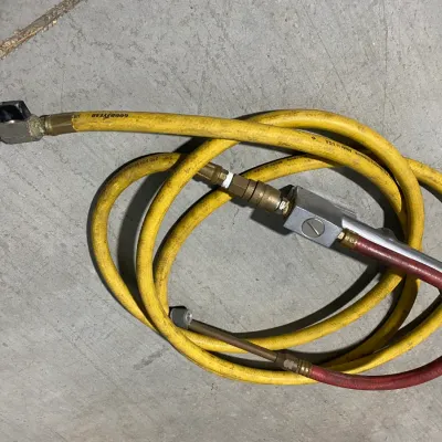 Sale Photo Thumbnail #15: Coiled yellow Goodyear 3/8-inch air hose with attached pneumatic fittings and a red whip hose extension.