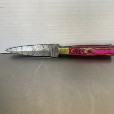 Sale Photo Thumbnail #65: Damascus steel dagger featuring a double-edged blade, brass bolster, and a vibrant pink and brown laminated wood handle.