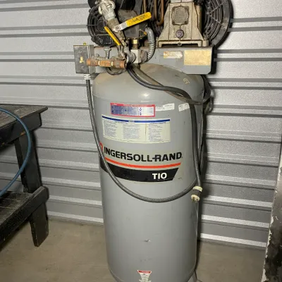 Sale Photo Thumbnail #12: Ingersoll-Rand T10 vertical air compressor, showing some wear and dust from typical garage use.