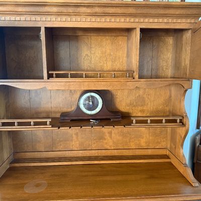 Sale Photo Thumbnail #13: A vintage two-piece wooden hutch featuring a top cabinet with louvered doors, open shelving, and plate grooves, sitting on a base with three central dovetail drawers, two side cabinets, and two wide bottom drawers. Features classic brass-toned hardware. P