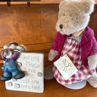 Sale Photo Thumbnail #157: A two-piece decorative lot featuring:
- A Boyds Bears & Friends plush teddy bear wearing a red and white plaid dress, a knit maroon cardigan sweater, and a lace collar. Includes original paper hang tag.
- A figurine depicting a boy climbing a wall with th