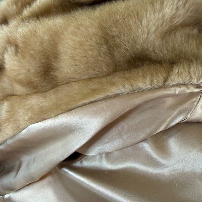 Sale Photo Thumbnail #274: A stylish Jones New York faux fur coat in a warm honey-blonde/tan color. Features a textured, ruffled collar, tiered panel design, and a smooth satin-like lining. Includes a gold-tone chain hanging loop. Size Large (L). Made in China. Appears to be in ver