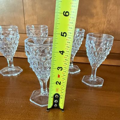 Sale Photo Thumbnail #116: A set of five vintage clear pressed glass goblets featuring a textured diamond/point pattern on the bowl and a hexagonal footed base. Each goblet measures approximately 4.5 inches tall. All pieces appear to be in good vintage condition with no visible chi