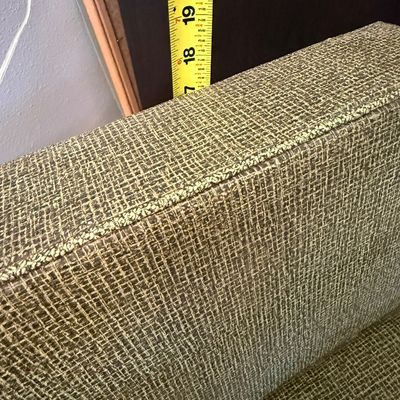 Sale Photo Thumbnail #246: A vintage child-sized armchair featuring a mid-century modern aesthetic. It is upholstered in a textured green woven fabric with light-colored wooden armrests and legs. The chair shows some signs of wear, including light scuffs and scratches on the wooden