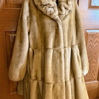 Sale Photo Thumbnail #267: A stylish Jones New York faux fur coat in a warm honey-blonde/tan color. Features a textured, ruffled collar, tiered panel design, and a smooth satin-like lining. Includes a gold-tone chain hanging loop. Size Large (L). Made in China. Appears to be in ver