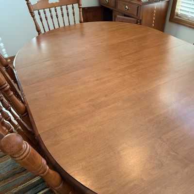 Sale Photo Thumbnail #5: NOT CHERRY IN COLOR.  A classic wooden dining set featuring an oval extension table and six matching Windsor-style chairs. The set includes two armchairs and four side chairs, all featuring turned spindle backs and legs. The table measures approximately 7