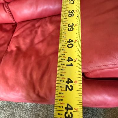 Sale Photo Thumbnail #97: A vibrant red leather loveseat by Natuzzi. Features plush, overstuffed armrests and back cushions. Shows some light wear and creasing consistent with gentle use, but remains in good, comfortable condition. Includes original Natuzzi documentation. Measures