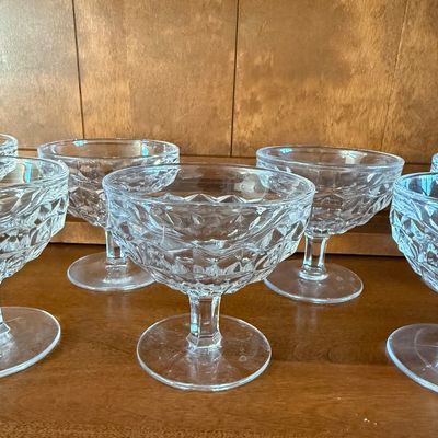 Sale Photo Thumbnail #111: A matching set of eight vintage clear pressed glass dessert or sherbet cups. Features a classic diamond-cut textured pattern on the bowls with short, sturdy stems and round bases. Ideal for serving ice cream, fruit, or puddings. All pieces appear to be in