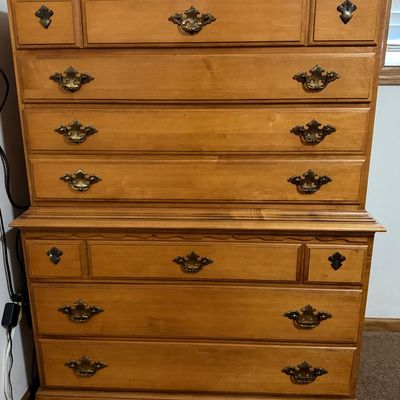 Sale Photo Thumbnail #217: A vintage solid wood chest-on-chest tallboy dresser manufactured by Crawford Furniture of Jamestown, New York. Features a classic colonial style with brass-toned batwing drawer pulls, bracket feet, and a total of seven drawers (including two faux-triple d