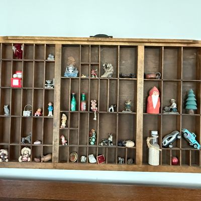 Sale Photo Thumbnail #194: A vintage wooden printer's type drawer repurposed as a hanging shadow box display case. Measures approximately 32 inches wide by 16.5 inches tall. The lot includes a large assortment of miniature collectibles, figurines, and novelty items as shown, includ