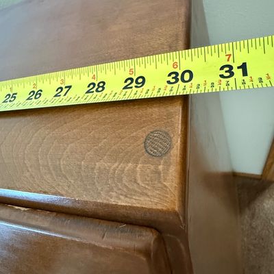 Sale Photo Thumbnail #166: A vintage wooden slant-front secretary desk featuring a drop-down writing surface that opens to reveal an interior organizer with small drawers and mail slots. The lower section includes three large drawers and a row of four smaller drawers, all accented 