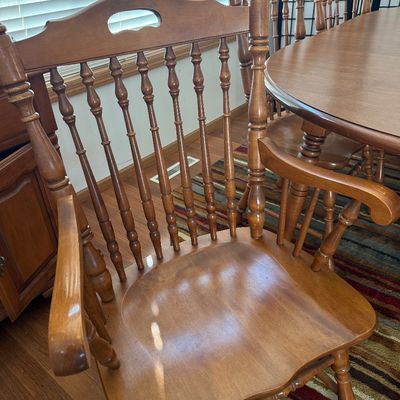 Sale Photo Thumbnail #4: NOT CHERRY IN COLOR.  A classic wooden dining set featuring an oval extension table and six matching Windsor-style chairs. The set includes two armchairs and four side chairs, all featuring turned spindle backs and legs. The table measures approximately 7