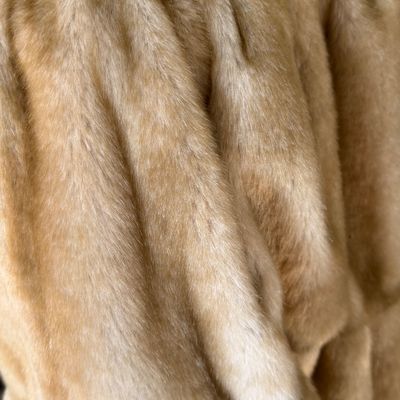 Sale Photo Thumbnail #275: A stylish Jones New York faux fur coat in a warm honey-blonde/tan color. Features a textured, ruffled collar, tiered panel design, and a smooth satin-like lining. Includes a gold-tone chain hanging loop. Size Large (L). Made in China. Appears to be in ver