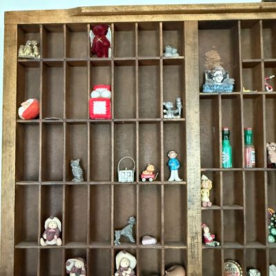 Sale Photo Thumbnail #197: A vintage wooden printer's type drawer repurposed as a hanging shadow box display case. Measures approximately 32 inches wide by 16.5 inches tall. The lot includes a large assortment of miniature collectibles, figurines, and novelty items as shown, includ
