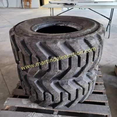 Sale Photo Thumbnail #46: Two heavy-duty tractor or industrial equipment tires with deep tread, stacked on a wooden pallet.