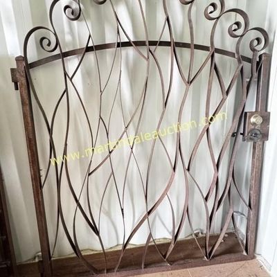 Sale Photo Thumbnail #18: Ornate wrought iron garden gate featuring a stylized organic branch design with scrollwork along the arched top, complete with a latch mechanism.
