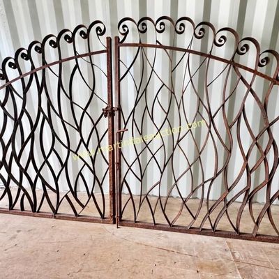 Sale Photo Thumbnail #19: Pair of vintage wrought iron garden gates featuring an organic, flowing branch-like design with scrolled top details and a rusted patina.