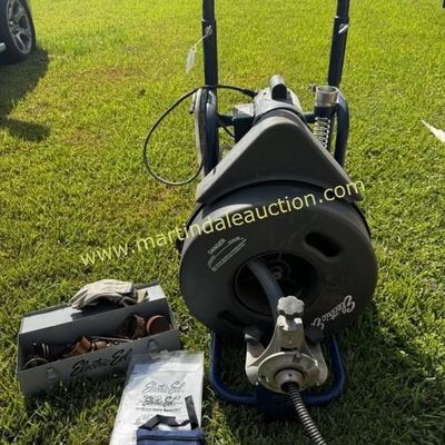 Sale Photo Thumbnail #34: Electric Eel Model RF drain cleaning machine on a wheeled frame, accompanied by a metal accessory box, manual, and small storage pouch.
