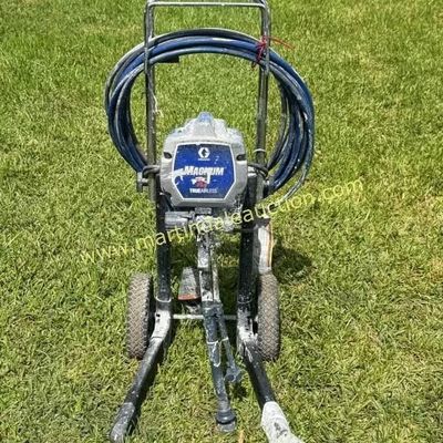 Sale Photo Thumbnail #24: Graco Magnum TrueAirless paint sprayer on a wheeled cart with attached hose, showing signs of previous use.