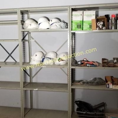 Sale Photo Thumbnail #43: Industrial metal shelving unit with multiple bays, holding various construction supplies including white hard hats, tools, and adhesives.