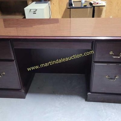 Sale Photo Thumbnail #4: Traditional double-pedestal executive desk in a dark cherry finish, featuring brass-tone bail pulls and a protective glass top.