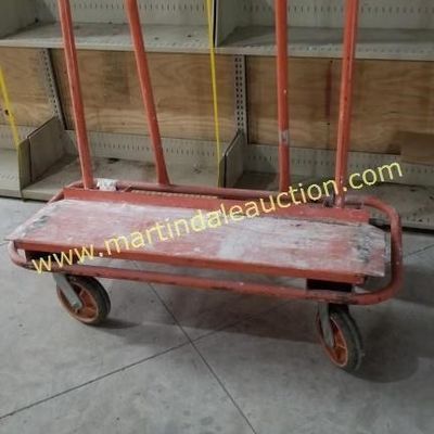 Sale Photo Thumbnail #47: Heavy-duty orange metal drywall and panel cart with four caster wheels, showing signs of wear from industrial use.