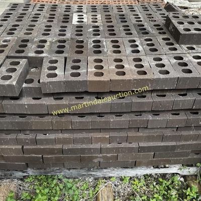 Sale Photo Thumbnail #10: Large pallet of dark brown three-hole construction bricks, suitable for building or landscaping projects.