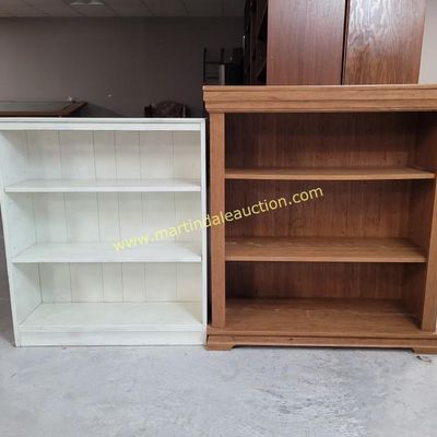 Sale Photo Thumbnail #51: Two low three-shelf bookcases, one painted white and the other in a natural wood finish, featuring classic crown molding details.