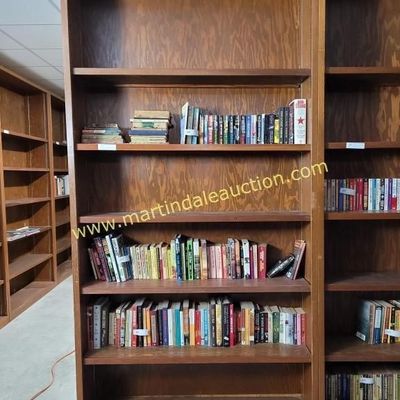 Sale Photo Thumbnail #54: Tall vintage wooden bookcases with adjustable shelves, filled with various paperback and hardcover books.