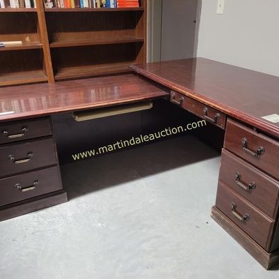 Sale Photo Thumbnail #6: Large L-shaped wooden executive desk with a dark cherry finish, featuring multiple drawers with brass-toned hardware and a keyboard tray.