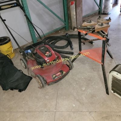 Sale Photo Thumbnail #56: Toro Recycler 22-inch walk-behind lawn mower with Personal Pace system, shown alongside a miter saw stand, a portable heater, and a collection bag.