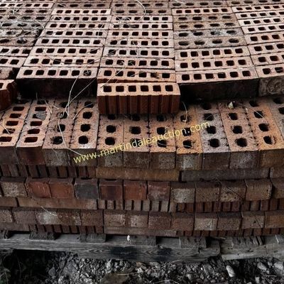 Sale Photo Thumbnail #12: Large stack of red clay bricks with core holes, piled on a wooden pallet.