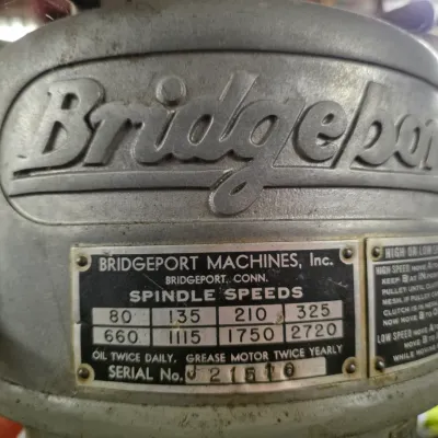 Sale Photo Thumbnail #58: Vintage Bridgeport milling machine head featuring the embossed logo and spindle speed plate with serial number J21510.