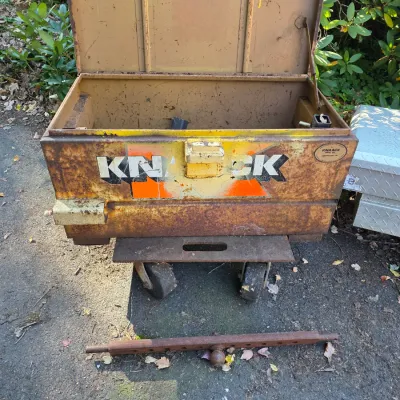 Sale Photo Thumbnail #9: Vintage Knaack heavy-duty steel jobsite tool box on wheels, showing significant surface rust and wear from industrial use.