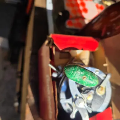 Sale Photo Thumbnail #17: Vintage Penn fishing reel with a green marbled handle, shown in its original red cardboard box.