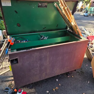 Sale Photo Thumbnail #7: Vintage Vanderman Manufacturing Company heavy-duty steel jobsite tool box on casters, featuring a rusted exterior and green painted interior with storage dividers.