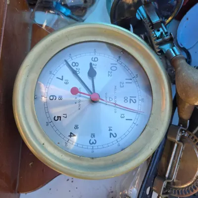 Sale Photo Thumbnail #24: Vintage Bell Clock Co. quartz ship's clock with a brass-toned bezel and 24-hour markings, shown alongside various vintage kitchen utensils.