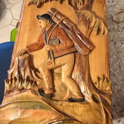 Sale Photo Thumbnail #3: Vintage hand-carved wooden relief plaque depicting a lumberjack carrying logs, featuring painted details and a rustic, folk art style.