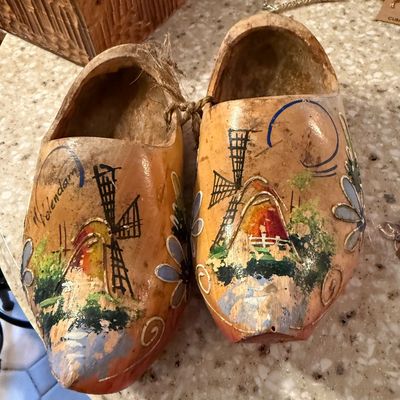 Sale Photo Thumbnail #2: Pair of vintage Dutch wooden clogs, hand-painted with a windmill scene and labeled "Volendam," showing some wear and paint loss.