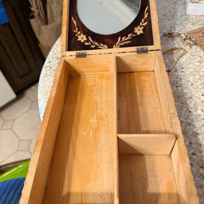 Sale Photo Thumbnail #4: Vintage carved wooden jewelry box with a hinged lid, featuring an interior mirror framed by inlaid floral details and three storage compartments.