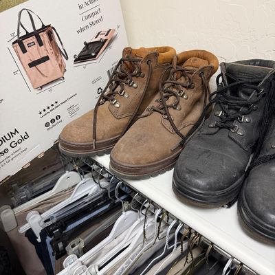 Sale Photo Thumbnail #119: Two pairs of Timberland-style ankle boots, one in brown nubuck and one in black leather, displayed on a closet shelf.