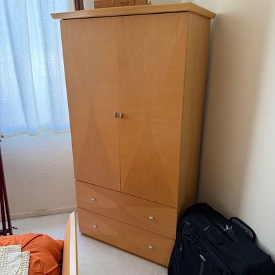 Sale Photo Thumbnail #158: Contemporary light wood armoire featuring a two-door upper cabinet and two lower drawers with simple metal pulls.